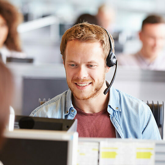 An employee talks on a headset via a cloud-based business telephone system.