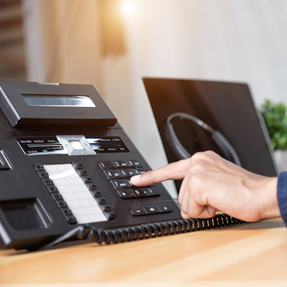 Excalibur employee serves customers using office telephone
