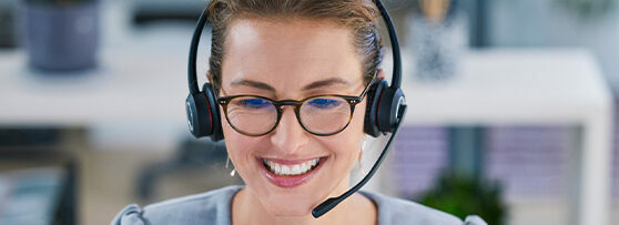 Office worker smiling, wearing a telephony headset