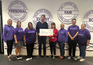 Members of Excalibur Communications and FearLess charity pose with a cheque donation, Swindon, Wiltshire.